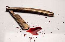 Dangerous Razor Bloodied On A Light Background. Razor With Bloody Smudges On The Blade.