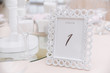 © Olga - Original white frame with geometric motif with table number for guests at the wedding