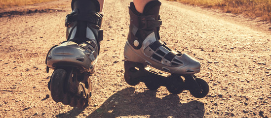 teenage girl rollerblading on the street on the road in the countryside on a summer evening  sunset