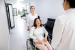 © Yakobchuk Olena - Smiling nurse transporting disabled in clinic woman stock photo