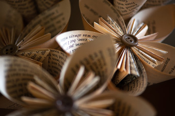 Stylish origami-type hand-made folded paper flowers constructed from buttons and pages from an old book