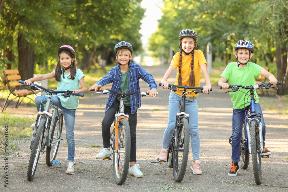 Cute children riding bicycles outdoors