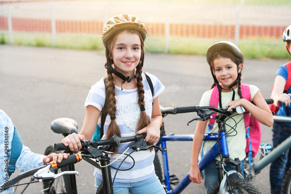 Cute children riding bicycles outdoors