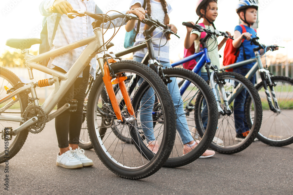Cute children riding bicycles outdoors