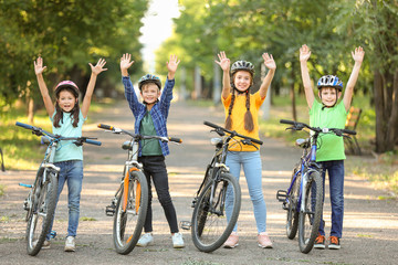 Cute children riding bicycles outdoors