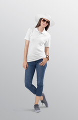 Wall Mural - Standing beautiful woman model wearing white plain polo t shirt in blue denim jeans pant. Wearing white had and sunglasses