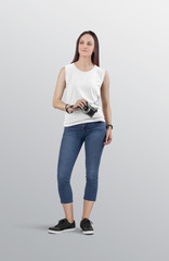 Wall Mural - Attractive woman model wearing white blank sleeveless shirt in blue denim jeans pant. Holding camera in her hand on isolated background