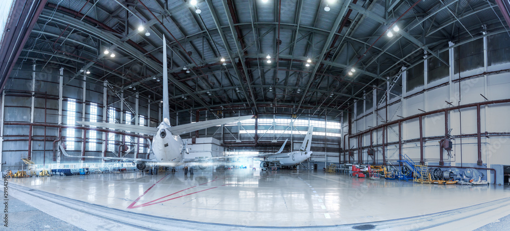 Passenger jet planes under maintenance. Checking mechanical systems for flight operations. Panorama of aircrafts in the hangar - obrazy, fototapety, plakaty 