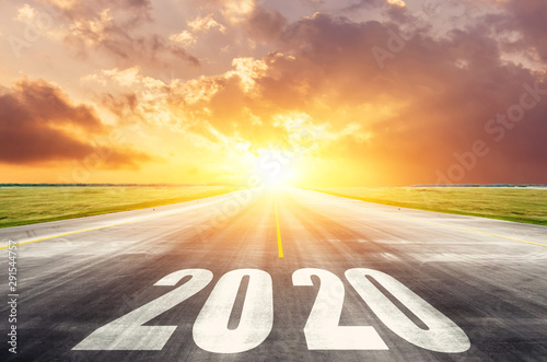 Fotografía Road asphalt road with the inscription 2020 year with the rising sun in the morning