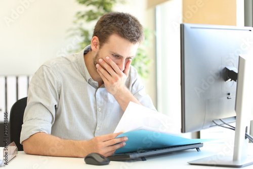 Fotografía Worried businessman discovering mistake on document