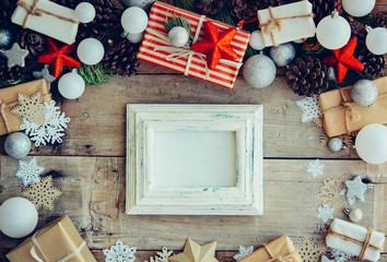 Wall Mural - Christmas background with frame and gift boxes on the wooden tab