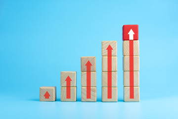 Wooden blocks stacking as step stair with red arrow up, blue background, Business growth success process concept, copy space