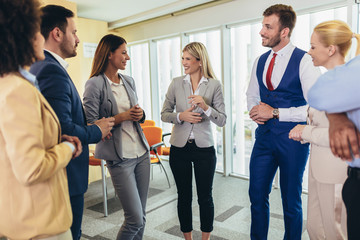 Wall Mural - Business team having a meeting standing in the office. Selective focus.