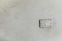 Old Light Switch On White Cracked Wall, Background And Space For Text, Isolated 