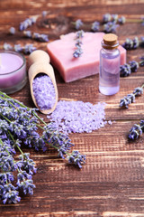 Wall Mural - Lavender flowers with oil in bottle, salt and soap on brown wooden table