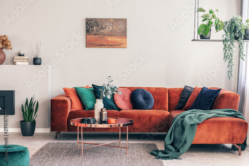 Fototapeta Stylish Round Table With Flowers Next To Corner Sofa Fototapeta Stylish Round Table With