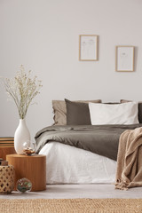 Wall Mural - Wooden nightstand table next to king size bed with white and grey bedding in simple bedroom interior