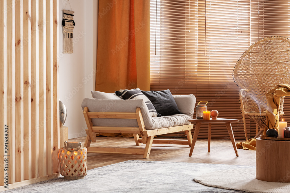 Obraz na płótnie Orange candle on wooden coffee table in cozy living room interior w salonie