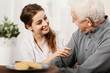 © Photographee.eu - Smiling young nurse sitting at table with senior patient