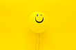 Leinwandbild Motiv Happiness emotion. Yellow balloon with smile on yellow background top view copy space