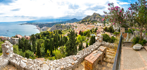 Wall Mural - Panoramic aerial view of Ionian seacoast near Isola Bella island and Taormina old town on Sicily, Italy. Mt Etna on the background