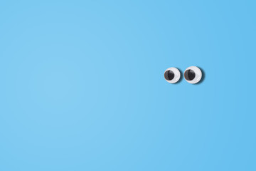 Abstract image of Cartoon eyes looking left side on blue background.