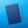 © Vitaly Korovin - Blue notebook with pen on paper backgorund. Business work notepad.