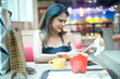 © creativeimages - Woman having food and drink after shopping at mall