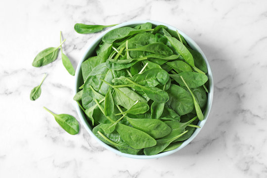 Fresh green healthy spinach on marble table, flat lay