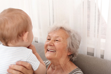 Wall Mural - Happy grandmother with little baby at home