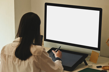 Young graphic designer working with computer isolated white screen and using pen and digital tablet for drawing.