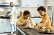 © zinkevych - Dad cooking dessert while two kids enjoying main meal at the table.