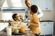 © zinkevych - In the sun-drenched kitchen a man and his two sons eating and chatting.