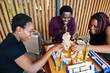 © AS Photo Family - Group of three african american friends play table games.