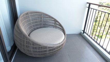 Outdoor beach chair on the hotel room balcony or terrace which made from natural wood called rattan and brown color round shape and look luxury for relaxing or sleeping or for party.