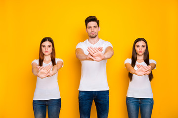 Poster - Portrait of strict mates crossing palms wearing white t-shirt denim jeans isolated over yellow background