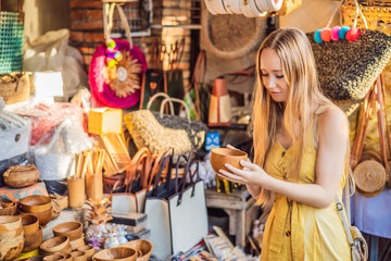 Wall Mural - Woman traveler choose souvenirs in the market at Ubud in Bali, Indonesia