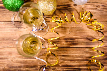 Wall Mural - Two wineglasses with champagne and different christmas decorations on wooden table. Top view