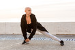 © Drobot Dean - Image of caucasian bald woman stretching her leg while working out