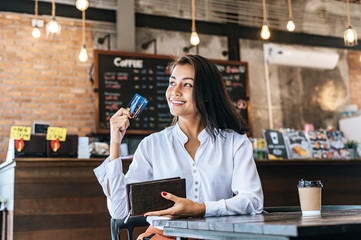 Accepting credit cards from a brown purse to pay for goods on coffee orders.