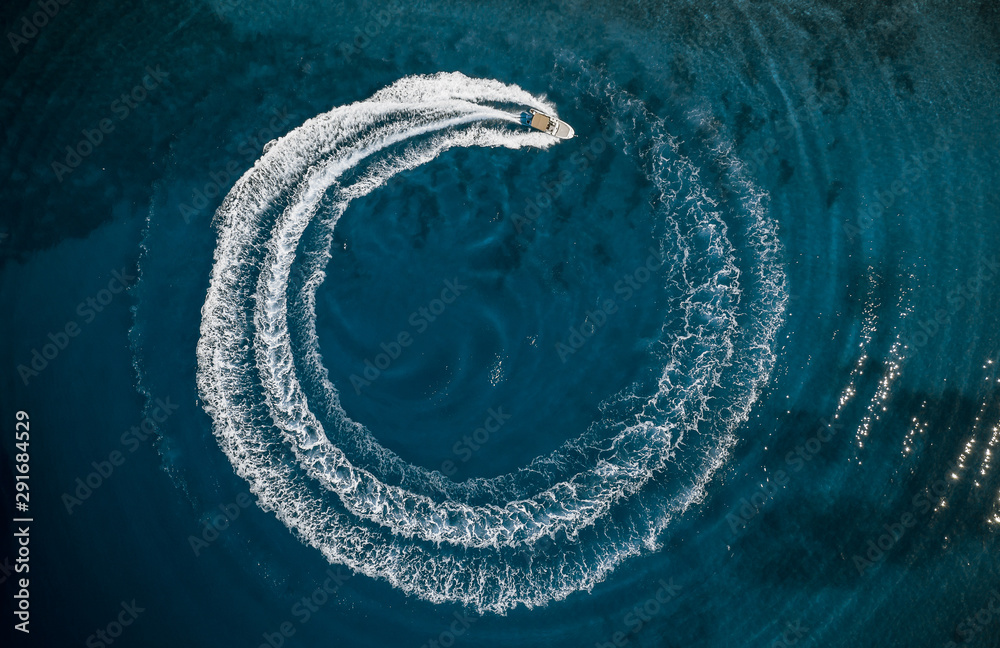 Speed boat in mediterranean sea making a cyrcle from bubbles, aerial view - obrazy, fototapety, plakaty 
