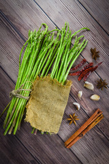 Wall Mural - Fresh asparagus bunch on dark background - Asparagus green with chilli garlic spices and shallot for cooking food