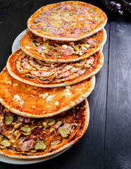 Wall Mural - Fresh pizzas with sausage and vegetables. On a wooden table.