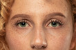 Beautiful young woman's eyes close-up shot. Female model with well-kept skin. Perfect skincare, human emotions, facial expression, beauty and cosmetics concept. Deep green color and eyebrows.