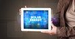 © ra2 studio - Young business person working on tablet and shows the inscription: SOLAR ENERGY