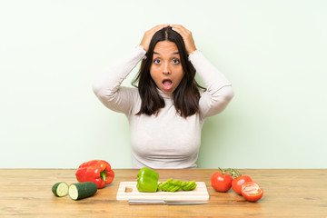 Young brunette woman with vegetables with surprise facial expression