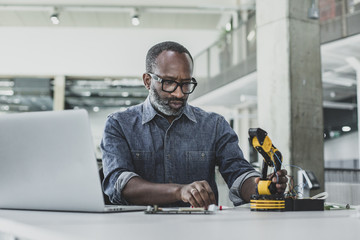 African American adult male working on robotics