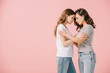 © LIGHTFIELD STUDIOS - side view of attractive women in t-shirts hugging isolated on pink