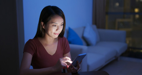 Poster - Woman use of mobile phone at home in the evening