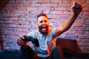 Emotional guy playing video game at home. Concept of gaming and technology. Relax